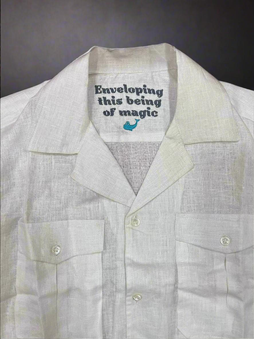 White Safari shirt with motivational poetry text on collar against a brown background