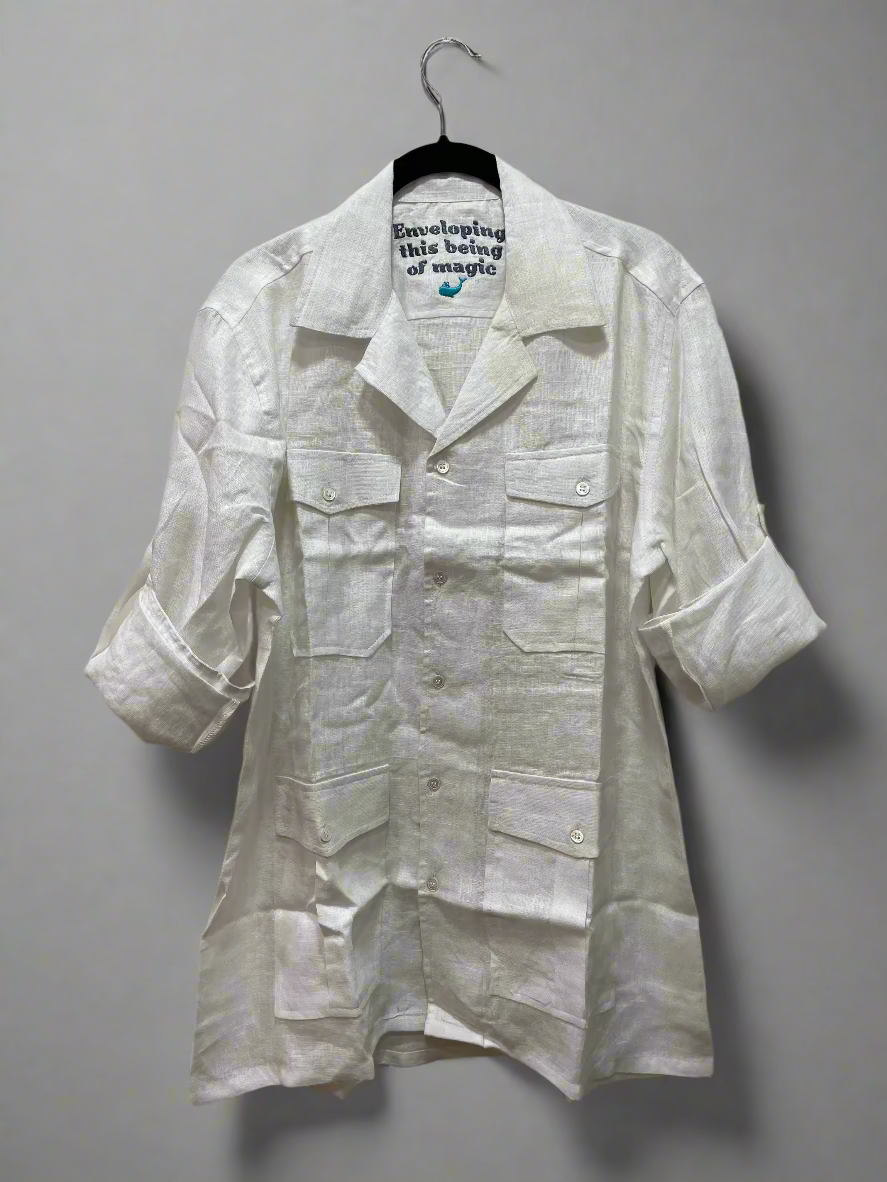 White safari shirt on a hanger against a plain background